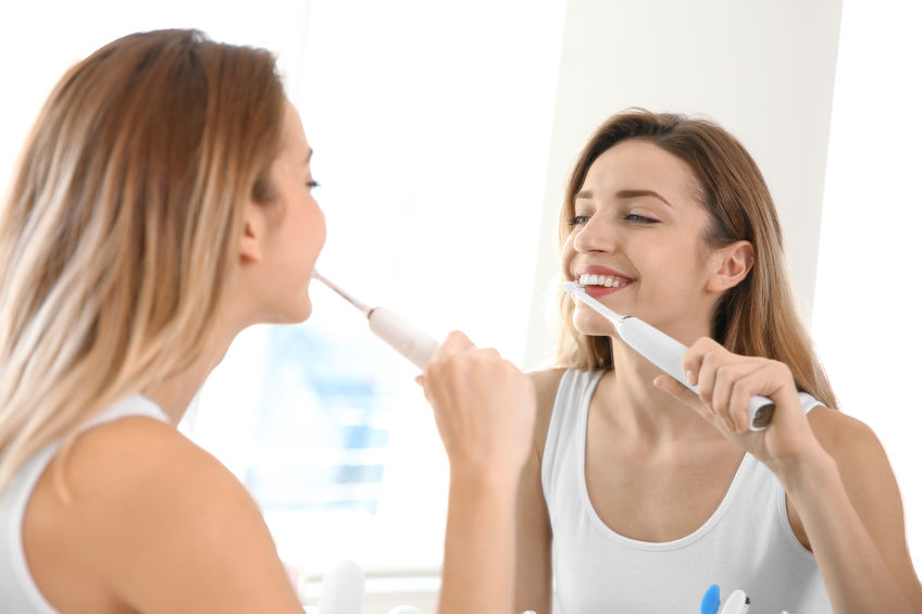 Young Woman Maintaining Oral Health at Home by Brushing Teeth