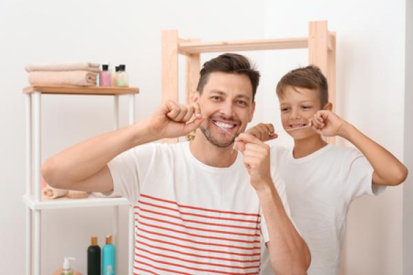 A man and his son flossing
