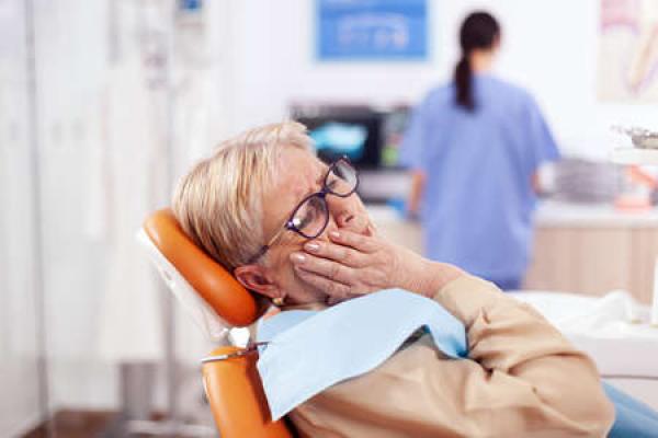 A woman sits in a dentist's chair, awaiting treatment
