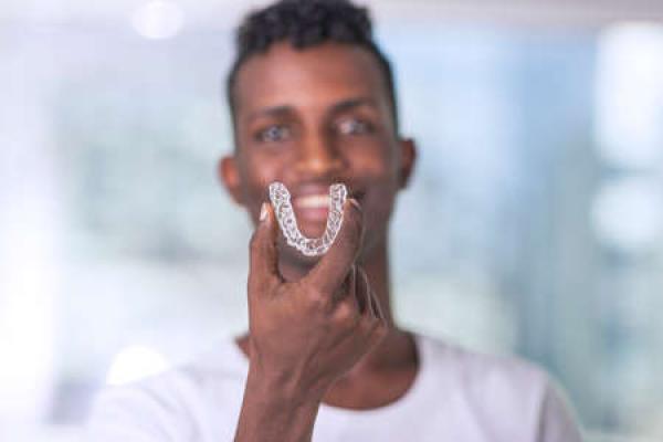 A man holds up his clear braces